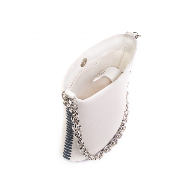 A white purse with silver chain and black strap.