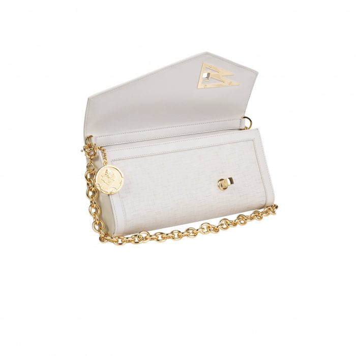 A white purse with gold chain and a coin.