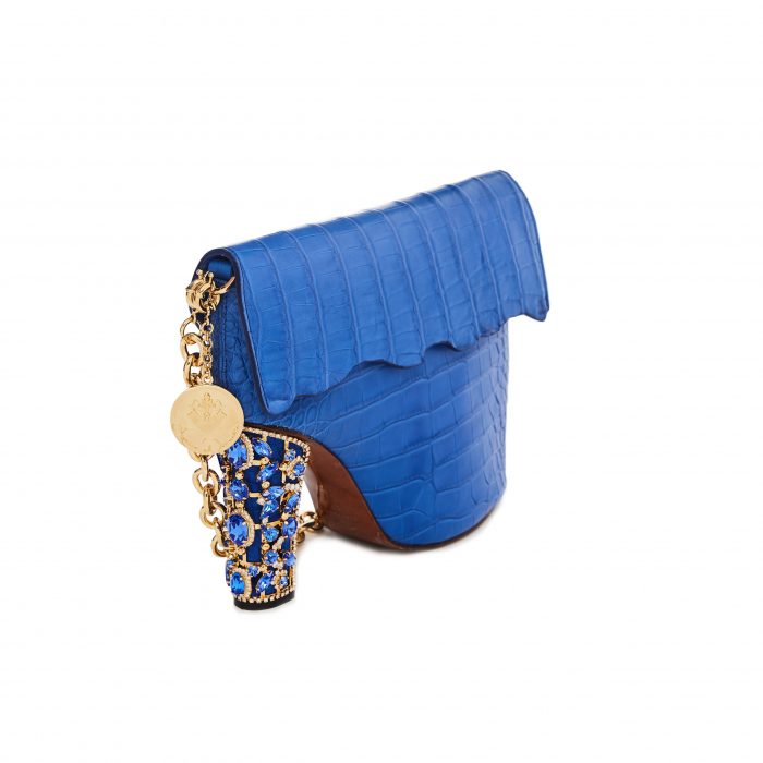 A blue purse with a gold chain and a coin.