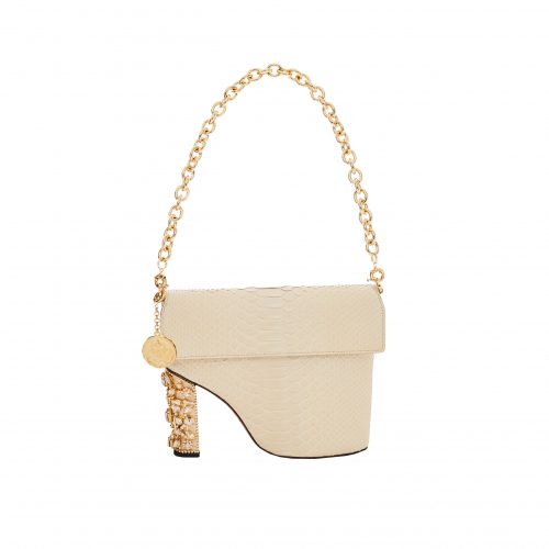 A white purse with gold chain and a heel.