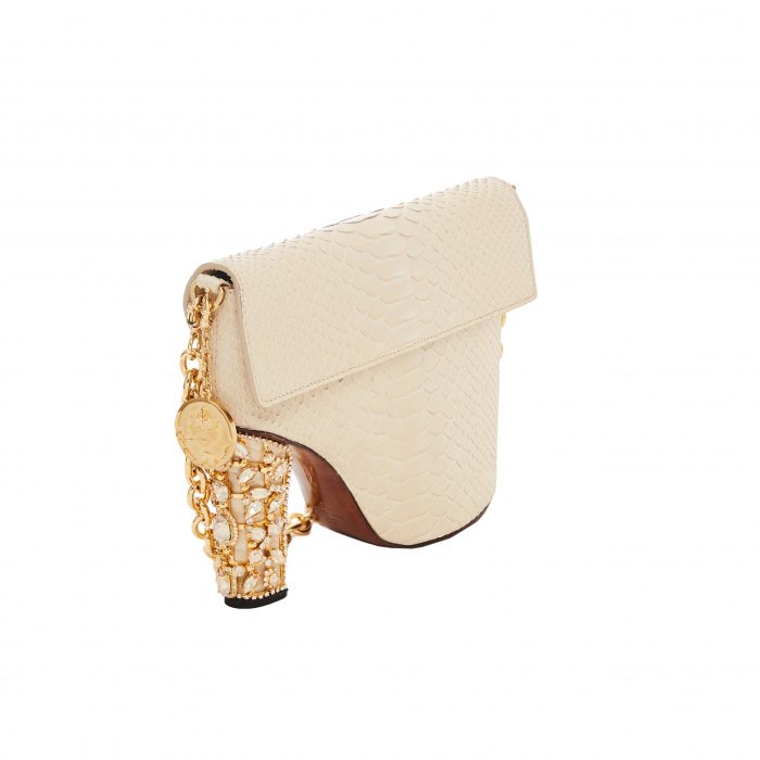 A white purse with a gold chain and a gold elephant charm.