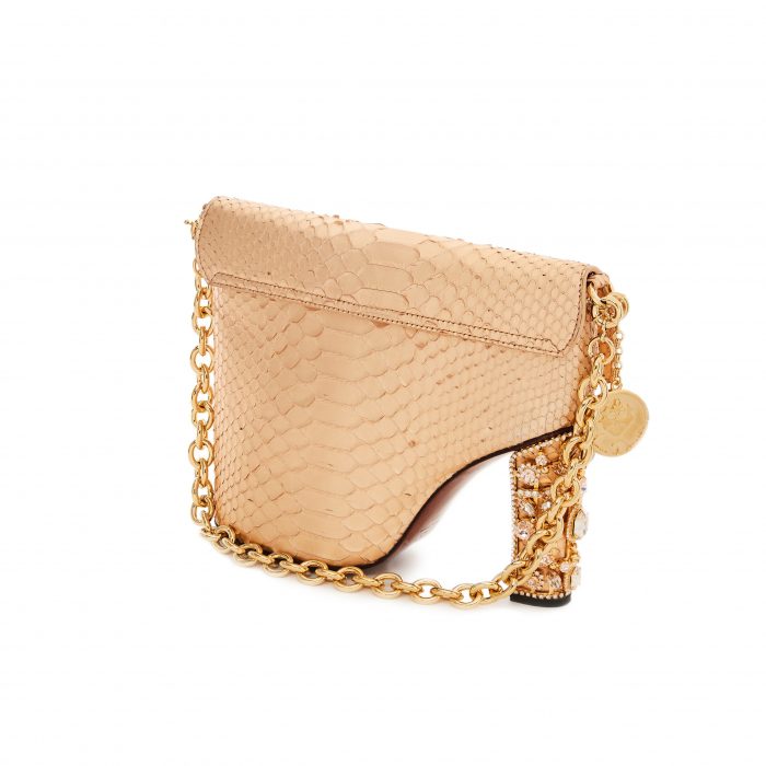 A beige purse with gold chain strap and a coin on the front.