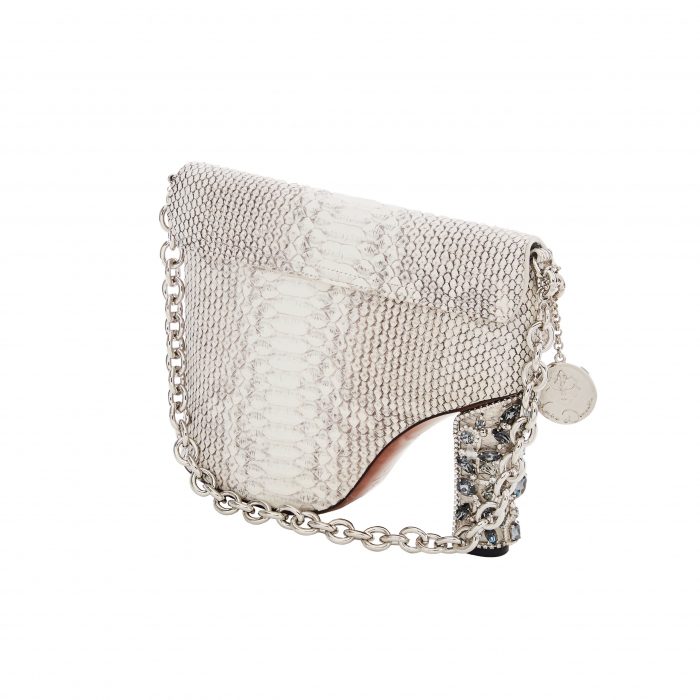 A white purse with silver chain and a heel.