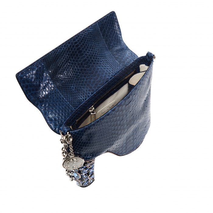 A blue purse with a silver chain and a cell phone.
