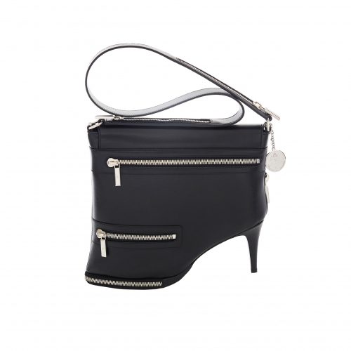 A black purse with silver zippers and a heel.