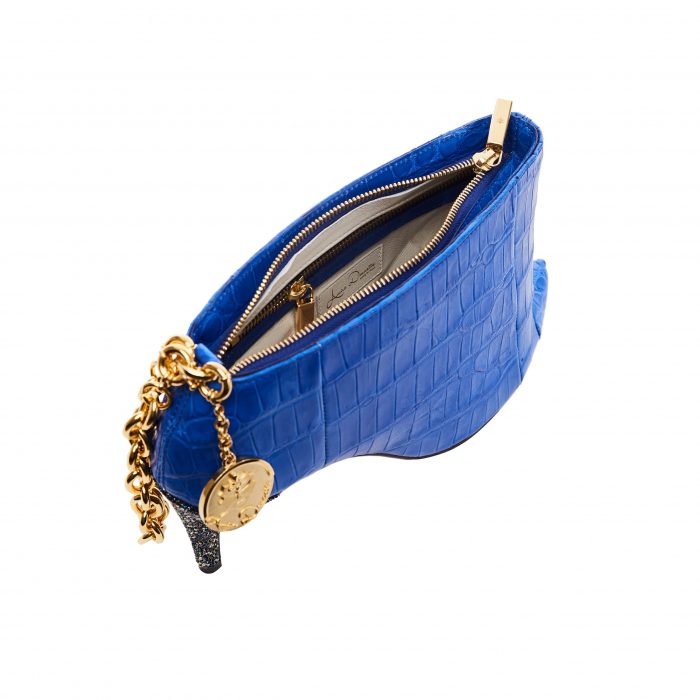 A blue purse with gold chain and a coin on it.