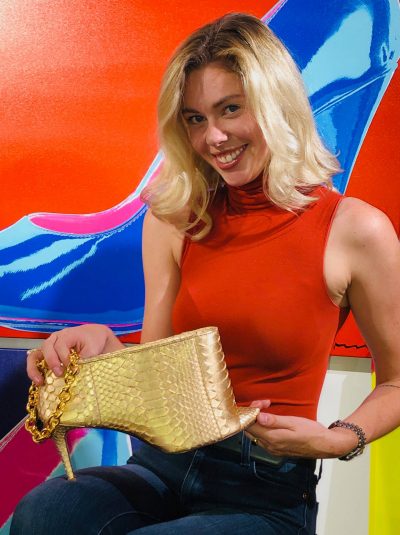 A woman holding onto a gold purse